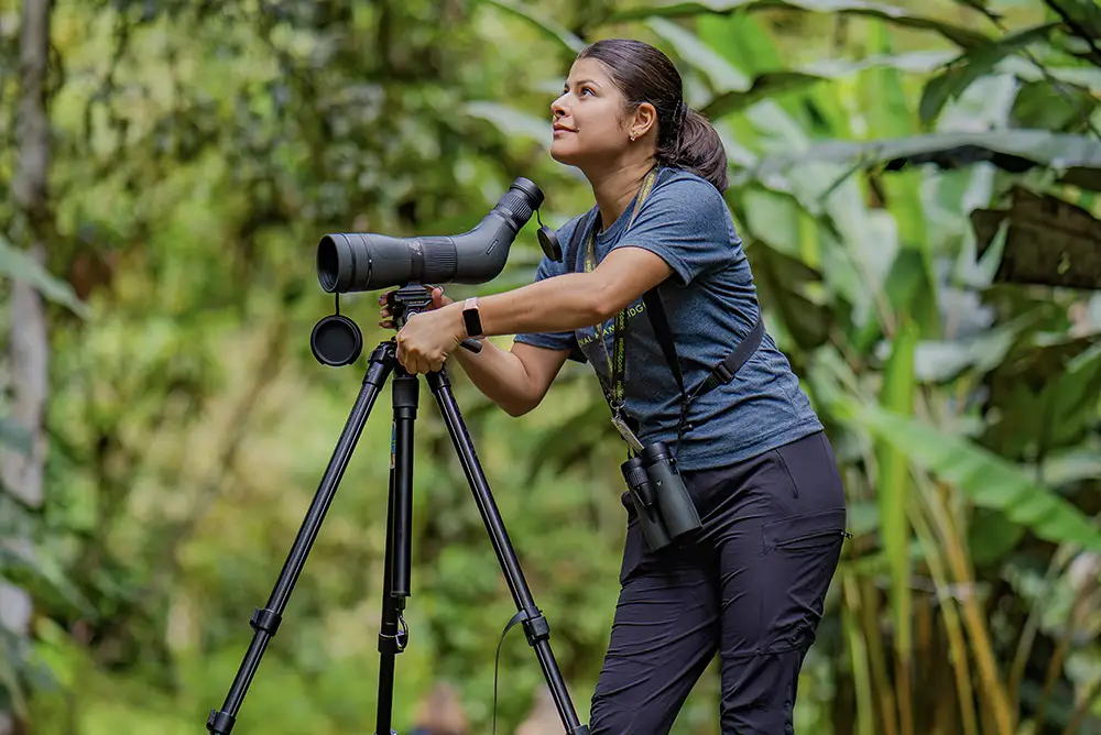 Sustainable Tourism in Arenal: How Mistico Puts It Into Practice Responsibly & Transparently 4 Guide using a spotting scope to show a small bird during a natural history walk in the Arenal rainforest.